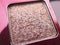 A close-up of pearlescent shimmery pink eyeshadow for creating eye makeup.  Beauty concept
