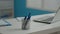 Close up of pens and laptop on white desk in empty cabinet