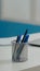 Close up of pens and laptop on white desk in empty cabinet