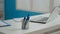 Close up of pens and laptop on white desk in empty cabinet