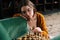 Close-up of pensive cute young woman wearing elegant eyeglasses making chess move with knight piece sitting in wooden