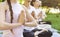 Close up of people making namaste gesture at yoga class outdoors