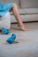 Close up of a perfect female legs. Woman applying moisturizer. Cropped side view portrait of woman`s perfect thin legs and blue