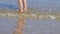 Close up of a person bare feet walking at a beautiful tropical beach.