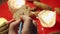 close-up of a person painting a Christmas or new year\'s toy with a brush against the background of cones and candles in