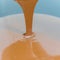 Close-up of a person pouring melted liquid chocolate onto a bowl