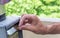 Close-up Of Person\'s Hand Inserting Ticket Into Parking Machine