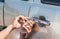 Close-up Of Person`s Young Man Locksmith Hand Opening Bronze Car Door With Lock picker