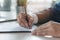 Close up person signing his signature to agreement document to guarantee financial loa