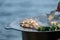 Close-up of a person stirring food in a cooking pot with a large metal spatula