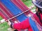 Close up of Peruvian lady in authentic dress spinning yarn by ha