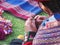 Close up of Peruvian lady in authentic dress spinning yarn by ha