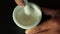 Close up pharmacist hand mixing white medicine powder in mortar