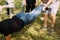 Close-up photo from above as a man in his arms climbs over the ropes and friends help him hold his legs.