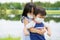 Close-up photo of adorable siblings hugging each other playfully wearing face mask