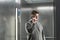 Close-up photo of ambitious office worker talking on her smartphone in the elevator and looking into the camera.. Portrait of a