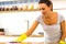 Close up photo of anxious girl polishing tabletop, making everything shine perfect, looking a major germophobe.