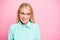 Close up photo of anxious person biting lips looking wearing teal turquoise shirt isolated over pink background