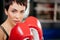 Close up photo of attractive young woman with brown eyes in red boxing gloves