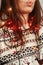 Close-up photo of beautiful brunette woman in white stylish sweater with reindeers tangled with colorful, red and