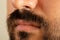 Close up photo of brown skinned man with long facial hair and moustache