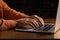 Close-up photo of businessman typing on laptop.