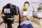 Close up photo of camera on tripod with a boy on LCD screen and blurred scene on background. Male child video blogger recording vl