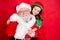 Close up photo of charming christmas father in eyeglasses eyewear and his elf in green hat cap hugging piggyback