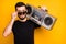 Close up photo of charming imposing guy hold boombox on his shoulder want listen music spring time trip touch modern