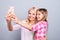 Close up photo cheer two people blond haired she her granny little daughter hold telephone make take selfies weekend