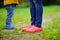 Close up photo of child and adult legs in rubber boots