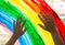 Close-up photo of child`s hands touch painting rainbow on window. Family life background. Image of kids leisure at home