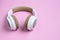 Close-up photo of cool headphone on pink background. Music concept