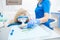 A close-up photo of a dentist`s hand taking a sterile instrument from a metal tray.