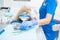 A close-up photo of a dentist`s hand taking a sterile instrument from a metal tray.