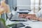 Close-up photo of female hands with accessories working on portable computer in a modern office, using keyboard.