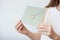 Close-up photo of female hands holding invitation envelope with a gold wax seal, a gift certificate, a postcard, wedding