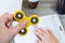 Close up photo of fidget spinner in hand. Student playing yellow fidget spinner while studying. Top above high angle close up pov