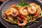 Close-up photo-fried spaghetti or fried noodles Pasta with tomato sauce and shrimp, basil, and tomatoes on a black plate On a