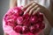 Close-up photo of gorgeous bouquet of pink roses in a hat box. Woman hands with manicure