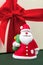 Close-up photo of gypsum colorful santa claus on the gift box over green background.