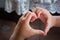 Close-up photo of hands a child making fingers showing as a heart symbol to say that I love you. The heart shape tells the love