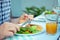 Close up photo of hands man eating salad, quinoa and fish on terrace