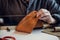 Close-up photo the hands of a skilled shoemaker make a bag from a piece of genuine leather