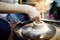 Close-up photo of hands of woman making clay object