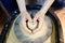 Close-up photo of hands of woman making clay object