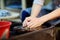 Close-up photo of hands of woman making clay object