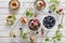 Close-up photo of homemade cakes with mascarpone cheese, cinnamon, strawberries, blueberries and beautiful wild apple tree floweri