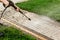 Close up photo of a man hands, cleans a tile of grass in his yard. High pressure cleaning