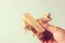 Close up photo of man\'s hand holding wooden toy airplane over wooden background. filtered image. aspiration and simplicity concept